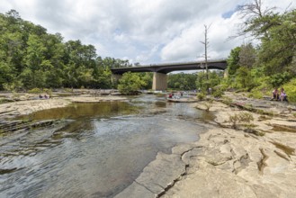 People playing on the rocks under the Little River Falls Bridge in Little River Canyon Falls Park