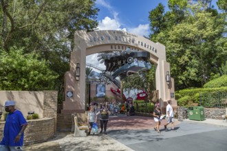Masked park guests exiting under the entrance sign for the Rock 'n' Roller Coaster ride at Disney's