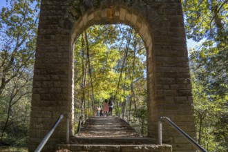 Park visitors walking across the Swinging bridge constructed in 1939 at Tishomingo State Park in