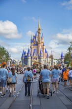 Family walks toward Cinderella's Castle at the end of Main Street in the Magic Kingdom at Walt
