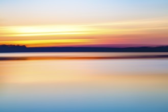 Motion blurred abstract lake at sunset background or wallpaper