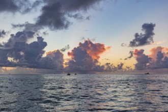 Colorful storm clouds behind the silhouette of offshore fishing boats in the Gulf of Mexico just