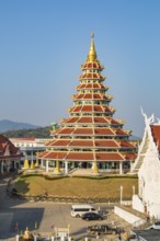 Nine tiered pagoda with gold dragons on each rooftop at Wat Huay Pla Kang in Chiang Rai, Thailand