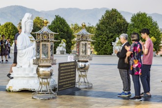 Visitors praying at the Guan Yin (Goddess of Mercy) statue at Wat Huay Pla Kang Temple in Chiang