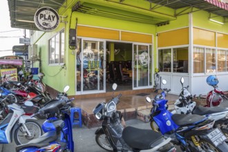 Motor scooters in front of the entrance to an Internet gaming business in Chiang Rai, Thailand