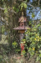 Buddahist shrine outside of a business on the sidewalk in Chiang Rai province of Northern Thailand