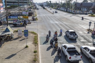Motor scooters move to the front of the line at traffic signals in Chiang Rai, Thailand