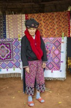 Traditionally dressed woman selling hand woven items in the Lu Mien-Yao tribe area of the Union of
