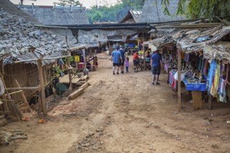 American tourists walking through the Long Neck Karen tribe (more properly called the Kayah Lahwi