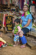 Tribal woman with two children in the Long Neck Karen tribe (more properly called the Kayah Lahwi