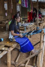 Tribal woman weaving scarves to be sold in the Long Neck Karen tribe (more properly called the