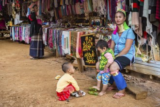 Tribal woman with two children in the Long Neck Karen tribe (more properly called the Kayah Lahwi