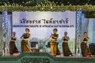 Traditional Thai dancers perform on a lighted stage at the night market in downtown Chiang Rai,