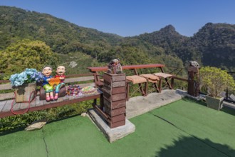 Ceramic statue of Thai couple holding a heart on a bench at the Doi Phamee coffee shop and
