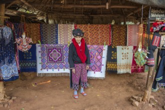 Traditionally dressed woman selling hand woven items in the Lu Mien-Yao tribe area of the Union of