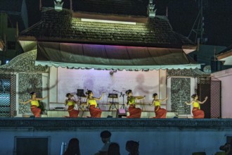 Traditional Thai dancers perform on a lighted stage at the night market in downtown Chiang Rai,
