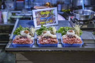 Thai street vendor offers hot pot meal package for customer to cook on a hot pot at their table at