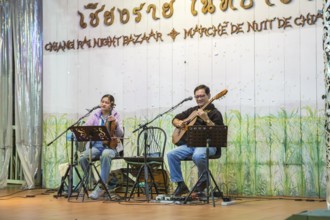 Musicians performing on a lighted stage at the night market in downtown Chiang Rai, Thailand