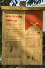 Wooden sign in Thai and English describes the Doi Tung Royal Villa inside the Doi Tung tourist