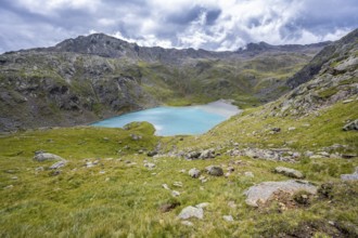 Light blue mountain lake Trüber See in a barren mountain landscape, seven-lake hike, Stubai Alps,