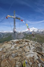 Böses Weibl summit with summit cross and colourful prayer flags, view of picturesque mountain