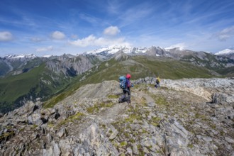 Mountaineers on a hiking trail, view of picturesque mountain landscape with snow-covered summit of
