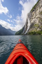 Kayak trip on the Geirangerfjord at the waterfall The Seven Sisters, tip of a red kayak in the