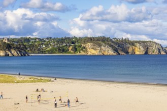 Young people playing beach volleyball on a sand beach a sunny summer day by the sea, Crozon