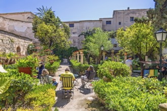 Lush green beautiful garden with visitors at Banys Arabs a historic sites in Palma, Banys Arabs,