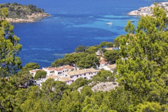 Aerial view at a coast village by the mediterranean sea with white houses by a blue sea bay and