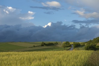 Dramatic cloudy sky with approaching storm and last rays of sunshine, Frankenhain, dark cloud wall,