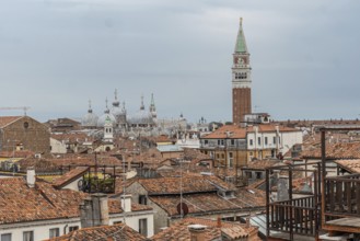 Red tiled roofs, chimneys and church domes dominate the venetian skyline with saint marks campanile