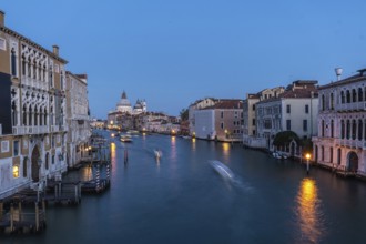 Motorboats creating motion blur are navigating grand canal with basilica di santa maria della