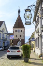 Special sign of the Hotel Pfauen, in the background the Königschaffhausen Tor, an old town gate of