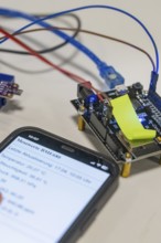 Close-up of a smartphone next to electronic components on a table, Nagold Youth Research Centre,