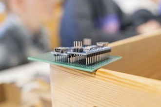 Microcontroller board on a wooden surface in a workshop environment, Youth Research Centre Nagold,