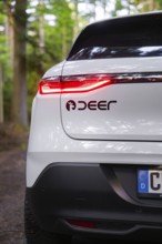 Close-up of a tail light with forest in the background, Renault Megane, Deer E Carsharing, electric