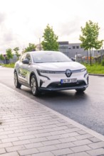 White electric car from Renault parked on a city street under a cloudy sky, Renault Megane, Deer E