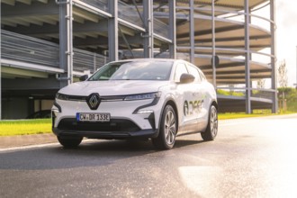 White Renault car standing on a street in front of a car park in the sunlight, Renault Megane, Deer