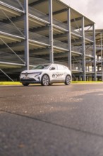 White Renault car in front of a multi-storey car park from a low perspective, Renault Megane, Deer