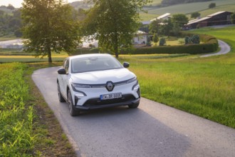 Electric car driving on a rural road, surrounded by green nature and trees, Renault Megane, Deer E-