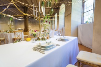 Festively laid table in a room with fairy lights and windows, a warm and inviting atmosphere, event