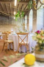 Elegant wedding decoration in a rustic ballroom with candles and flower arrangements, event and