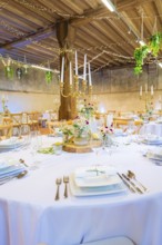 Round table beautifully set with flowers and candlesticks, surrounded by elegant fairy lights