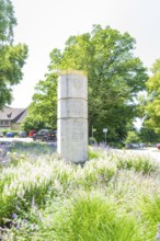 Stone monument surrounded by blooming summer meadows and green foliage, event and wedding location