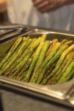 Seasoned green asparagus on a tray in a kitchen ready to be served, event and wedding location