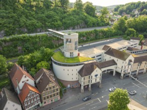 Modern building with green space, surrounded by half-timbered houses and hills, Calw, Black Forest,
