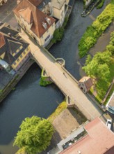 River with stone bridge and neighbouring historic buildings from the air, Calw, Black Forest,