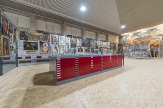 Gallery exhibition with red cabinets and paintings on the wall, historical art exhibition in the