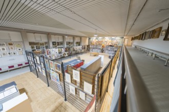 View of a diverse collection of artworks in a modern gallery on an upper floor, historical art